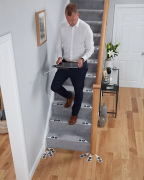 A specialist measuring a staircase with a tablet during a home visit
